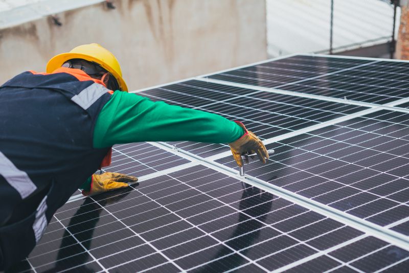 Technician installing solar panels on a residential rooftop
